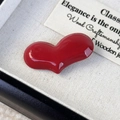 Dettaglio della molletta a cuore rosso lucido in una confezione regalo nera - Borgogna
