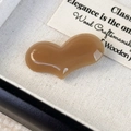 Close-up of heart-shaped acetate hair clip with a polished caramel brown glossy finish - Milk Coffee