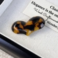 Macro shot of tortoiseshell acetate heart hair clip on beige velvet display background - Tortoise