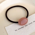 Dettaglio di elastico per capelli ovale rosa con fascia nera su uno sfondo minimalista - Rosa Loto