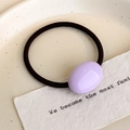 Dettaglio di una perla ovale color lavanda lucida su un elastico per capelli nero - Viola Chiaro