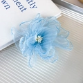 Close-up of light blue organza flower hair clip with delicate white stamens - Blue