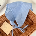 Dettaglio di un foulard triangolare in cotone a quadretti blu e bianchi su un cesto - Quadri Blu Bianco