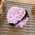 Detail of pink fabric rose hair claw clip with tiered satin petals and black grip - 8cm Hair Claw