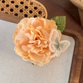 Detailopname van handgemaakte abrikooskleurige bloem haarspeld met geborduurde vlinder en blad - Champagne Bloem (24880B)