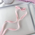 Detalle de una pinza para el pelo rosa con cristal de corazón sobre bandeja de vidrio - Rosa