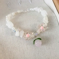 Detail of beaded bracelet with pink peach charm and white tulip pearls on linen - White