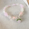 Close-up of pink and white beaded bracelet with cute peach charm and tulip flowers - Pink