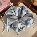 Dettaglio dell'elastico in raso azzurro con piccoli fiocchi in nastro bianco delicati - Blu