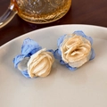 Close-up of elegant floral earrings with blue and yellow mesh petals in a white ceramic dish - Blue and Yellow Flower (17322C)