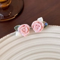 Dettaglio di orecchini a fiore in ceramica rosa con smalto iridescente su piatto beige - Rosa Rosa Cangiante (5# 21368B)