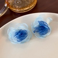 Detailed close-up of blue organza flower earrings on a white ceramic plate - Blue 3D Flower (24923B)