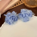 Close-up of blue fabric flower earrings on a white wavy ceramic plate in a French setting - Blue Flower (24970B)