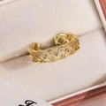 Gros plan détaillé d'une bague papillon plaquée or avec zircons sur coffret velours - Style Entrelacé Creux en Maille (16791B)