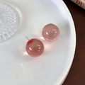 Detail von rosa Harz-Kugelohrringen mit transparentem Finish auf Keramiktablett - Transparentes Rosa