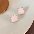 Nahaufnahme rosa quadratischer Harzohrstecker auf einem weißen Keramiks टेबल - Rosa Quadrat (25018A)