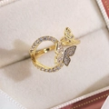 Macro de bague papillon dorée avec sertissage de zircons sur une boîte à bijoux - Style de Design Double Papillon (16297A)