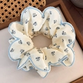 Gros plan d'un chouchou floral vintage avec broderie de dentelle bleu marine sur tissu - Bord Fleuri Bleu (25045B)