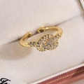 Détail d'une bague papillon dorée avec zircons incrustés sur écrin en velours crème - Style Micro-incrusté Nœud Doré (15642B)