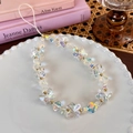 Detailed shot of an iridescent butterfly beaded phone strap on a decorative plate - Iridescent Colorful
