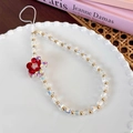 Close-up of iridescent cube beads and a red flower charm on a beaded phone wrist strap - Colorful Red Flower