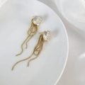 Detail van Franse camelia-oorbellen met witte bloembladen en gouden kettingkwastjes - Goud & Wit