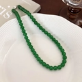 Detail view of green beaded necklace with silver round clasp on white ceramic tray - 8mm / 8mm Necklace