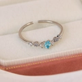 Macro view of heart-shaped blue zircon ring with opal accents on beige velvet - Adjustable Open / Blue Zircon Heart Style(25093B) / Silver
