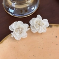 Dettaglio ravvicinato di orecchini a fiore bianco con cristalli e perline dorate su ceramica - Stile Petali Sovrapposti (18# 24831A)