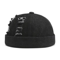 Dettaglio del cappello docker in denim nero con strappi consumati e bordo arrotolato - Nero