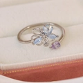Detail of silver floral open ring with blue and purple gemstones in a jewelry box - Blue Zircon Blooming Style(25099B)
