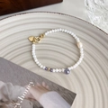 Detail eines Perlenarmbands mit Süßwasserperle und farbigen facettierten Edelsteinen - Weiße Perle