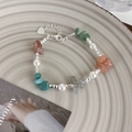 Dettaglio del bracciale di perle con pietre colorate e ciondolo a cuore su vassoio - Pietra Triturata Multicolore