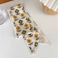Detailed close-up of yellow and green floral silk twilly scarf used as a bag accessory - Sunflower