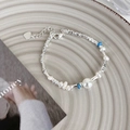 Dettaglio del bracciale con perle d'argento, perline blu e ciondolo a forma di cuore - Perla d'acqua dolce