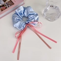Detail of light blue satin scrunchie with pink ribbon bow on a white table surface - Large / Blue