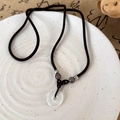 Macro dettaglio del ciondolo Ping'an in giada bianca con perline retrò su corda intrecciata - Stile Principale