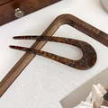 Macro shot of acetate U-shaped hair pin with tortoiseshell pattern on wood tray - Mocha Blue