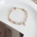 Detail eines Perlenarmbands mit pastellfarbenen Erdbeerkristallen und Sternanhängern - Bunt