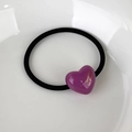 Macro detail of high-elasticity black hair tie with purple acrylic heart and gold lettering - Purple Heart