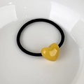 Detail of high-elasticity black hair tie with a yellow acrylic heart and La France text - Yellow Heart