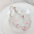 Dettaglio di un ciondolo per telefono con perline rosa e lavanda e fiocco su piatto - Rosa (23296A)