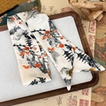 Detailed macro shot of ink wash art twilly scarf on traditional wooden tray - Mountain Pavilion