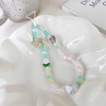 Bunte Tulpen-Handykette mit Pastell-Glasperlen und Herz-Anhänger in einer Keramikschale - Hauptstil