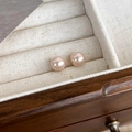 Primer plano de pendientes de perlas rosa champán con brillo radiante en un joyero de madera - 8mm / Rosa Champaña (8mm)