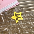 Detalle macro de pinza para el pelo con estrella amarilla sobre cristal ondulado - Pentagrama amarillo