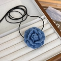 Dettaglio macro del ciondolo a fiore di camelia in denim con strati di tessuto blu - Piccolo / Azzurro