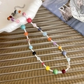 Detail of colorful beaded necklace with adjustable silver lobster clasp on textured surface - White Chain (23643A)