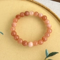 Detail eines facettierten Edelsteinarmbands auf besticktem Stoffhintergrund - Orange Mehrfarbig (23707B)