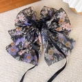 Dettaglio ravvicinato di un fermaglio per capelli a fiocco in chiffon floreale - Nero Floreale